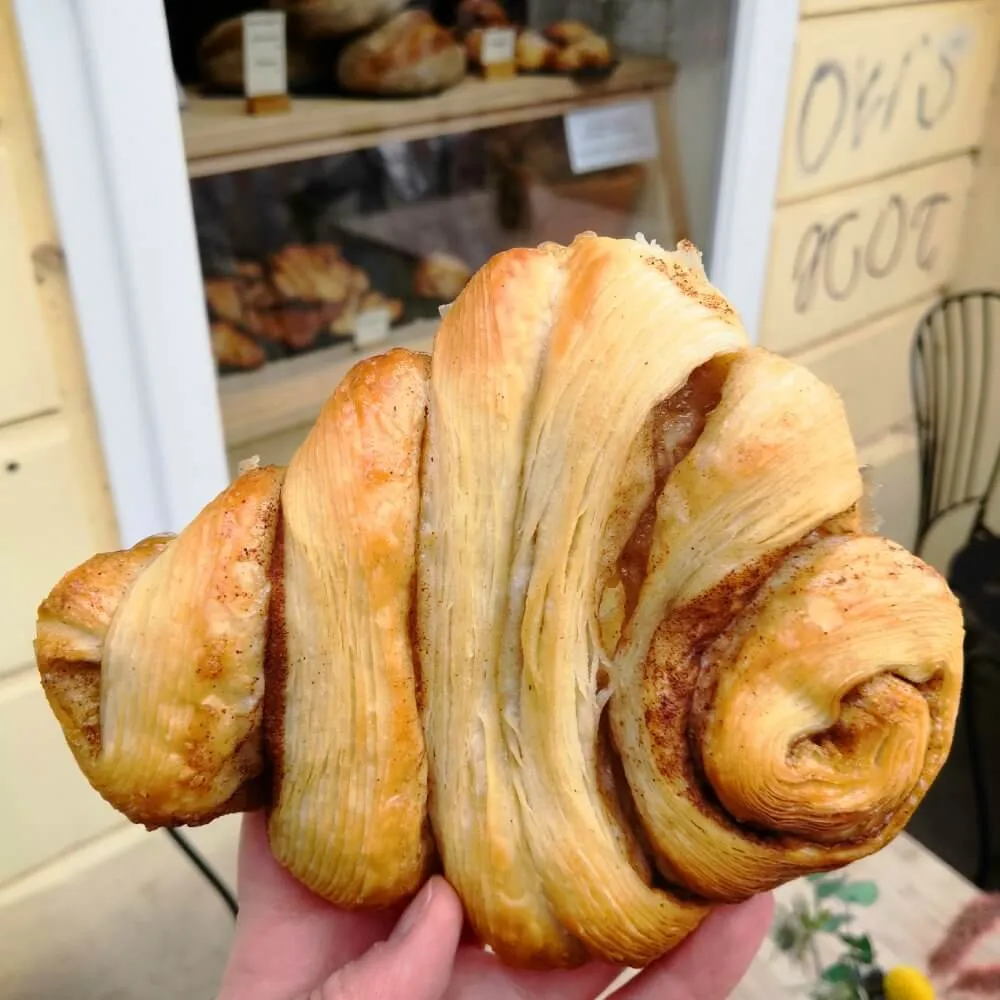 Veganes Franzbrötchen von ima vegan vor der Auslage des Geschäfts